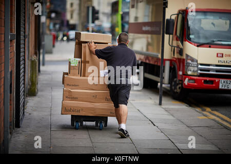 Ein Lieferwagen Parks keine der Gehsteig und doppelte gelbe Linie als Kurier bietet eine große Felder von Hand Trolley Stockfoto