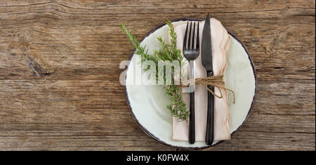 Tabelle mit Teller, Messer und Gabel auf hölzernen Hintergrund Stockfoto