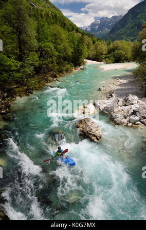 Kayaker schießen die kalte smaragdgrüne Wasser der oberen Fluss Soca in der Nähe von Bovec in Slowenien mit Veliko Spicje Berg in den Julischen Alpen Stockfoto