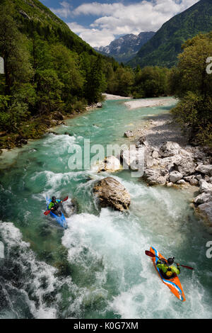 Kajakfahrer schießen die kalte Smaragdgrüne alpine Wasser der oberen Fluss Soca in der Nähe von Bovec in Slowenien mit Veliko Spicje Berg in den Julischen Alpen Stockfoto