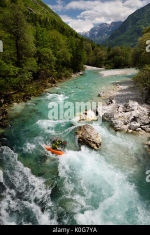 Kayaker schießen die kalte Smaragdgrüne alpine Wasser der oberen Fluss Soca in der Nähe von Bovec in Slowenien mit Veliko Spicje Berg in den Julischen Alpen Stockfoto