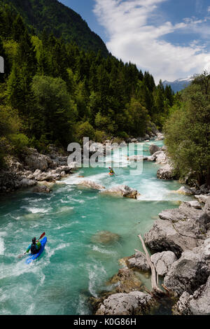 Kajakfahrer schießen die kalte Smaragdgrüne alpine Wasser der oberen Fluss Soca in der Nähe von Bovec in Slowenien mit Kanin Berge der Julischen Alpen Stockfoto