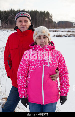 Ehemann und Ehefrau in warme Kleidung zusammenstehen im Winterwald Stockfoto