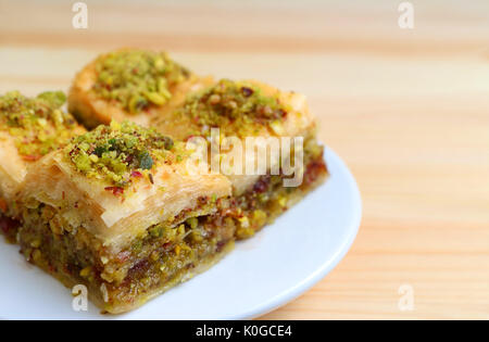 In der Nähe von Baklava mit Pistazien Süßigkeiten serviert Holztisch, verschwommenen Hintergrund Stockfoto