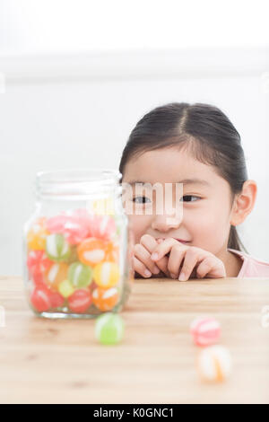 Porträt der lächelnde Mädchen Bonbons im Glas beobachten Stockfoto