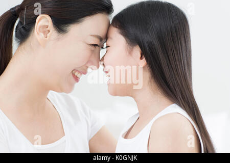 Seitenansicht Portrait von lächelnden Mutter und Tochter von Angesicht zu Angesicht Stockfoto