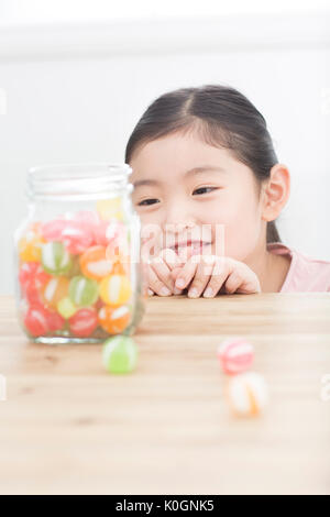 Porträt der lächelnde Mädchen Bonbons im Glas beobachten Stockfoto