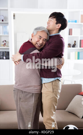 Lächelnd älterer Mann und seinem jungen Sohn umarmen Stockfoto