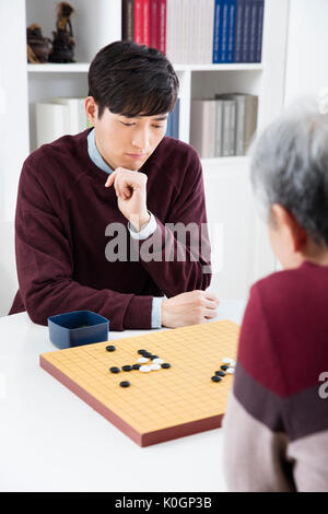 Portrait des jungen Mannes und seiner älteren Vater spielen Stockfoto
