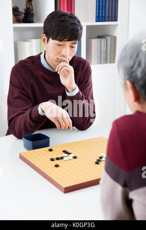 Portrait des jungen Mannes und seiner älteren Vater spielen Stockfoto