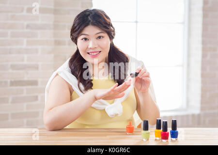 Portrait der junge lächelnde fette Frau tragen Nagellack Stockfoto