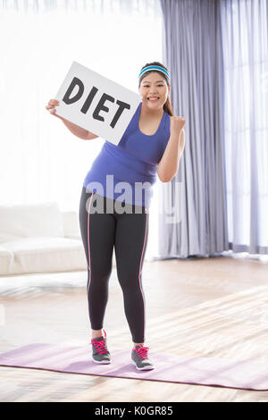 Junge lächelnde fette Frau entscheiden auf eine Diät zu gehen Stockfoto