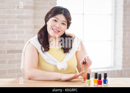 Portrait der junge lächelnde fette Frau tragen Nagellack Stockfoto