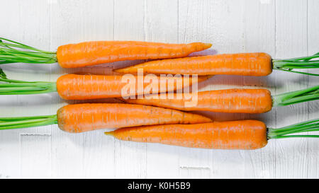 Geometrisch, frische Karotten auf einem weißen Tisch Ansicht von oben. Frische Karotten auf weißem Hintergrund. Stockfoto