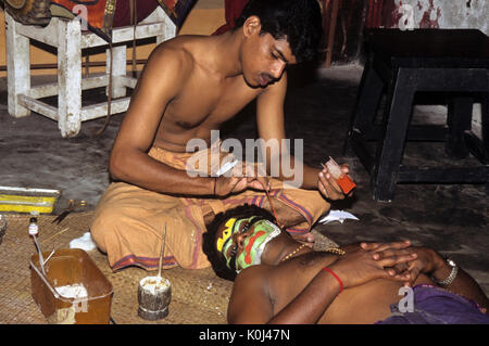 Assistant Anwendung stage Make-up zu Kathakali Performer, Cochin, Kerala, Indien Stockfoto