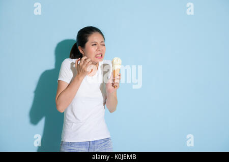 Süße attraktive Studentin nach dem Essen leckeres Eis Gefühl empfindliche Zähne schmerzlich unbequem und Traurigkeit Ausdruck in Blau wa Stockfoto