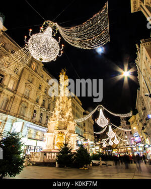 Nacht Atmosphärischer, Bewegung verwischt Graben, Shopping Besetzt überfüllten Wiens mit Gedenkstätte Pestsäule Pestsaule als Vordergrund, Wien, A Stockfoto