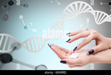 Weibliche Hände mit Sahne über DNA und Moleküle. Stockfoto