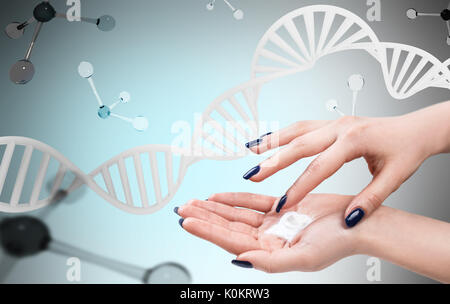 Weibliche Hände mit Sahne über DNA und Moleküle. Stockfoto