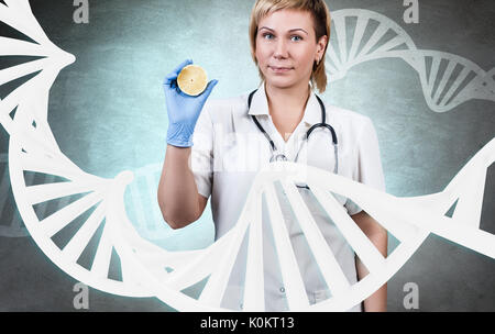 Frau Doktor ansehen unter großen DNA-Kette. Stockfoto