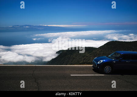 Dunkle Reisen mit dem Auto auf den Berg Serpentine über Wolken entlang dem Abgrund des Teneriffa gegen den Himmel. Roadtrip rund um die Kanarischen Inseln Stockfoto