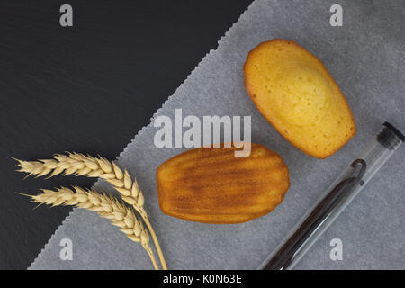 Frische Kuchen backen mini Madeleines auf schwarzem Schiefer Platte Stockfoto