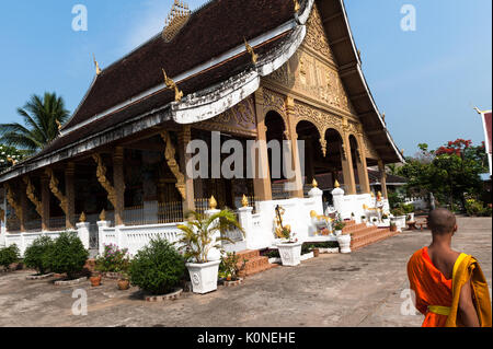 Ein Safran gekleideten buddhistischen Mönch Spaziergänge durch Wat Phonxay Sanasongkham, Luang Prabang, Laos. Stockfoto