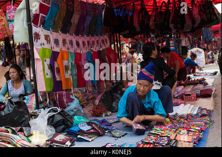 Eine ältere Frau aus Hmong Bergvolk sind Souvenirs zu einem Night Market in Luang Prabang, Laos. Stockfoto