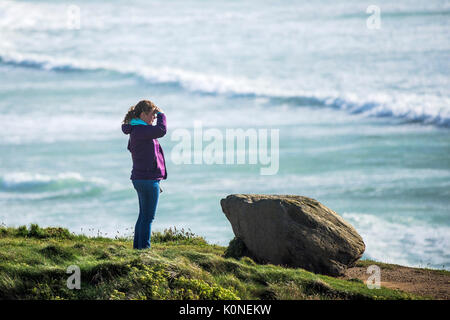 Eine Frau, die an der Küste mit Blick auf das Meer. Stockfoto