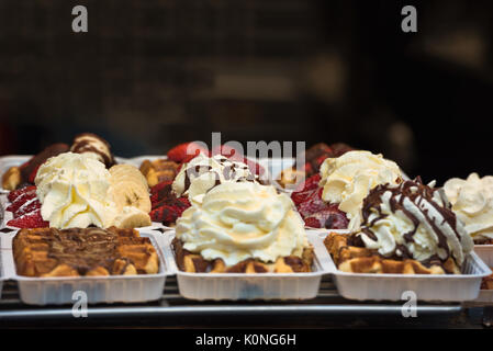 Reihen von Take away Straße Waffeln garniert mit Erdbeeren, Schokolade und Schlagsahne in Brüssel, Belgien Stockfoto