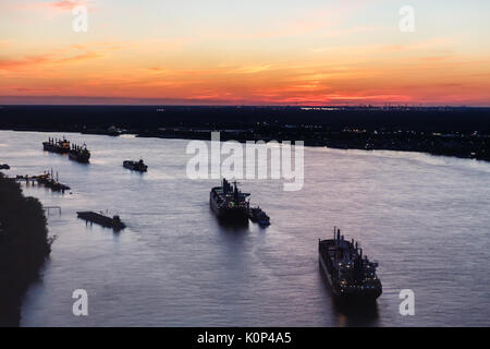 Öl Tanker bilden eine Linie entlang des Mississippi River bei Sonnenuntergang Stockfoto