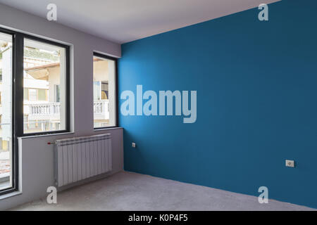 Unvollendete Innere der Wohnung im Bau mit grauem Beton, Fenster und Farbe Wand Stockfoto
