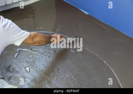 Arbeitnehmer stellt ein fließestrich auf Estrich im Haus Stockfoto