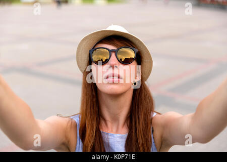 Hübsche junge Frau touristische nimmt Selfie portrait auf dem Platz der Stadt, Riga, Lettland. Schöne Studentin nimmt Foto für Travel Blog. Stockfoto