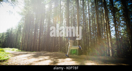 Mann laufen auf der Straße in den Wald während der sonnigen Tag Stockfoto