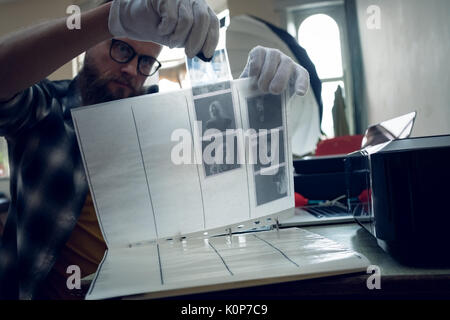 Fotograf, negative in Ordner, während Sie am Tisch sitzen Stockfoto