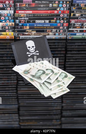 Gestapelte DVD-Filme & Schwarz pirate Portemonnaie und Chinesischen Renminbi Banknoten. Metapher der Chinesischen Urheberrecht IP-Diebstahl, US-China trade Krieg, China Piraterie. Stockfoto