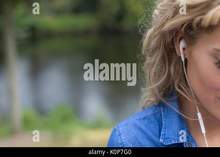 7/8 Bild der Frau hören Musik gegen die See Stockfoto