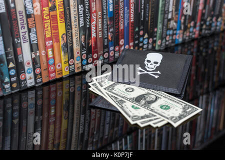 Gestapelte DVD-Filme & Schwarz pirate Portemonnaie mit uns einen Dollar Bills - für Urheberrecht & IP-Verletzung - US-chinesischen Handelsbeziehungen, US-China trade Krieg. Stockfoto