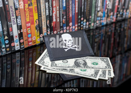 Gestapelte DVD-Filme & Schwarz pirate Portemonnaie mit uns einen Dollar Bills - für Urheberrecht & IP-Verletzung - US-chinesischen Handelsbeziehungen, US-China trade Krieg. Stockfoto