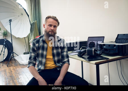 Porträt des Fotografen im Studio sitzen, Tabelle Stockfoto