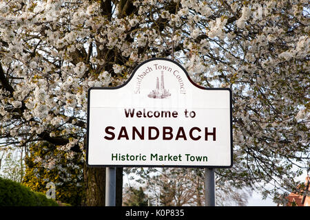 Wegweiser: Willkommen in Sandbach, der historischen Cheshire Markt der Stadt, mit einem Back Drop von spring blossom auf Bäumen Stockfoto