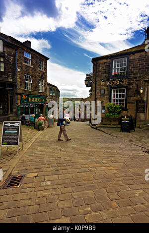 Menschen zu Fuß rund um den gepflasterten Hauptstraße im historischen Dorf Haworth, West Yorkshire, England, UK. Stockfoto
