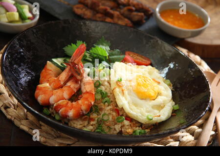 Nasi Goreng Gourmet, der Indonesischen gebratener Reis mit Garnelen, Ei und Chicken Satay Stockfoto