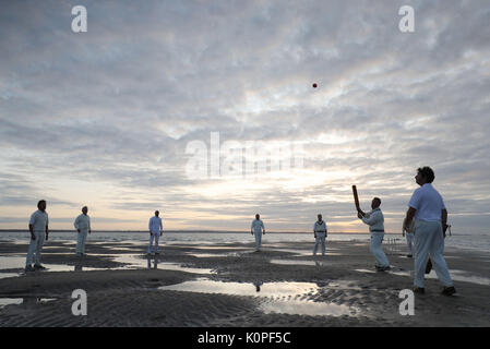 Am frühen Morgen übereinstimmen Aktion während der jährlichen Dornbusch Bank Cricket Match zwischen dem Royal Southern Yacht Club und die Insel Sailing Club der Cowes, die auf einer Sandbank in der Mitte des Solent, die nur an einige der niedrigsten Ebbe und Flut des Jahres ausgesetzt ist. Stockfoto