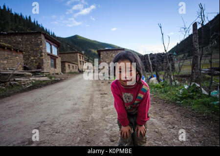 Ein neugieriger Tibetischen kid am Eingang Ihres kleinen und abgelegenen Dorf in der tibetischen Hochebene Stockfoto