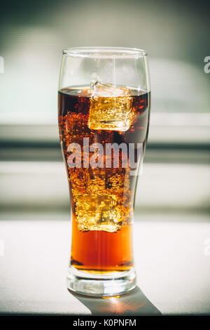 Schöne kalte Getränke von Cola mit Eiswürfeln in ein Glas auf einem grauen Hintergrund mit freier Speicherplatz Stockfoto