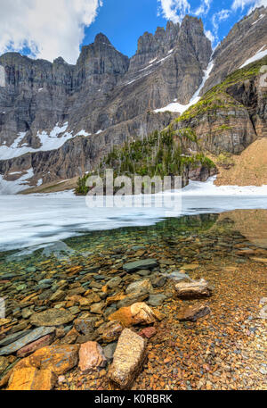 Eisberg Kerbe und die Ptarmigan Wand ragt 3000 Meter über meist Eisberg See im Juni im Glacier National Park, Montana Stockfoto