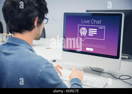 Symbole mit Live chat Text gegen über der Schulter auf der ernsten legerer Mann am Computer Schreibtisch arbeiten Stockfoto