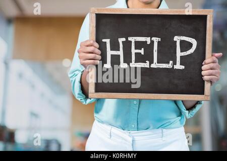 Digital composite Business woman holding eine Tafel mit Hilfetext Stockfoto